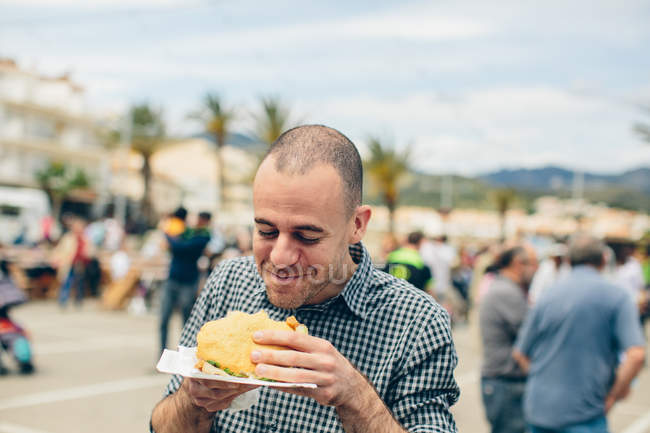 Homem comer frito patty — Fotografia de Stock