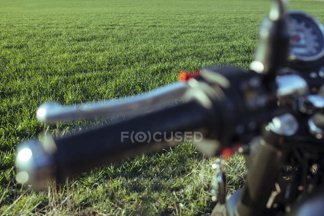 Мотоцикл кермового колеса і зелений луг — стокове фото