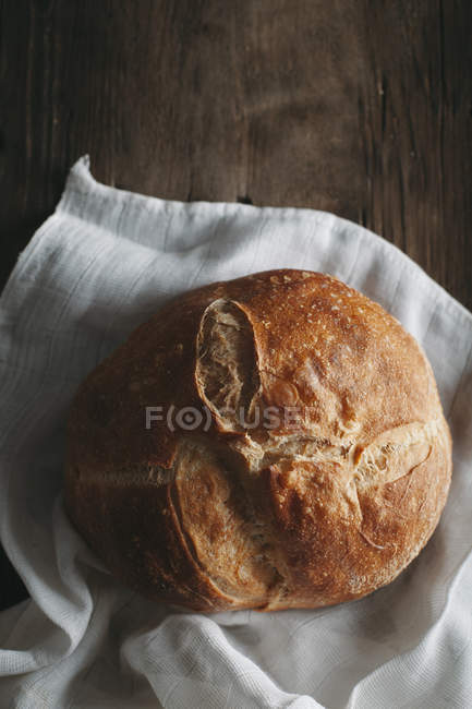 Буханка хлеба на белой ткани — стоковое фото