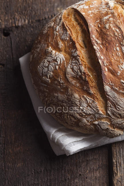 Loaf of bread on white cloth — Stock Photo