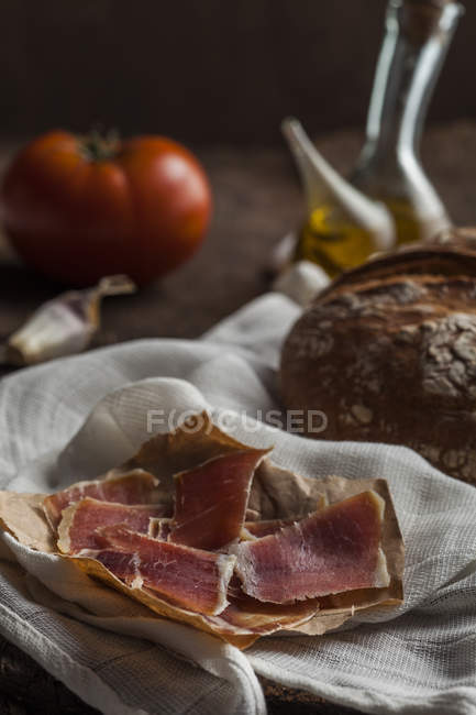 Pan y jamón sobre mesa de madera - foto de stock