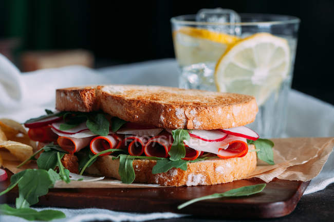 Sandwich con jamón, rábano y rúcula - foto de stock