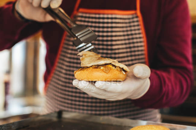 Köchin bereitet Hamburger zu. — Stockfoto