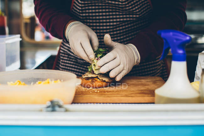 Male cook preparing hamburger — Stock Photo