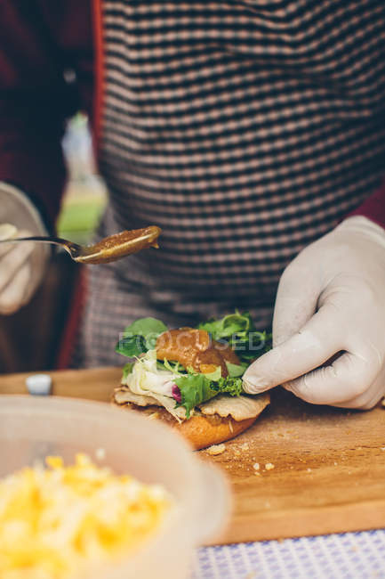 Cocinero macho preparando hamburguesa - foto de stock