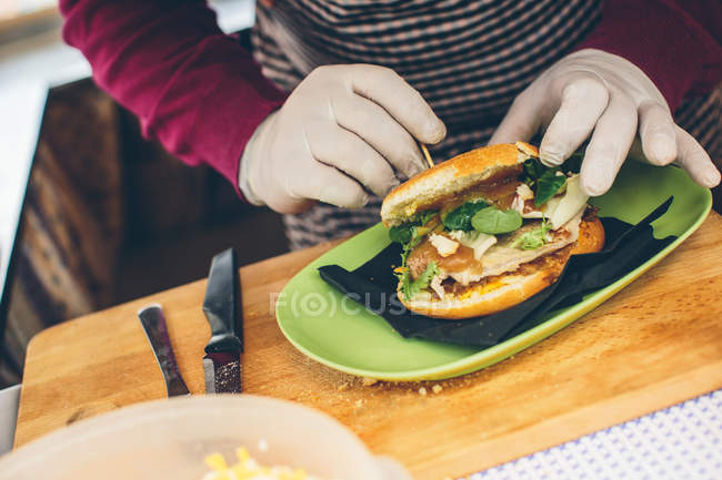 Cocinero macho preparando hamburguesa - foto de stock