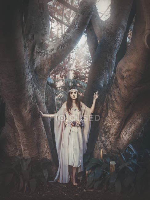 Brunette woman standing barefoot in forest — Stock Photo