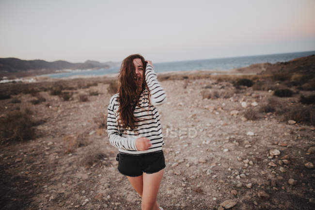 Bruna donna camminando contro del paesaggio marino — Foto stock