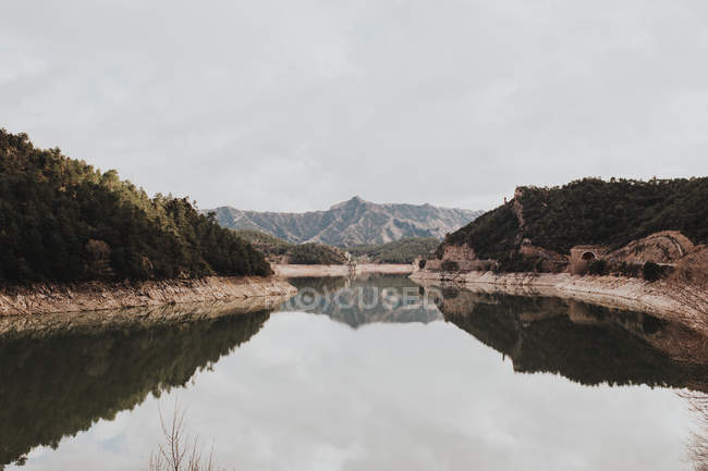 Montanhas refletindo em lago calmo — Fotografia de Stock