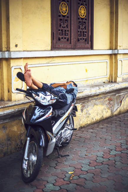 Homme dormant sur scooter — Photo de stock