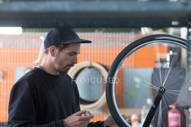 Homem de construção de bicicleta na oficina — Fotografia de Stock