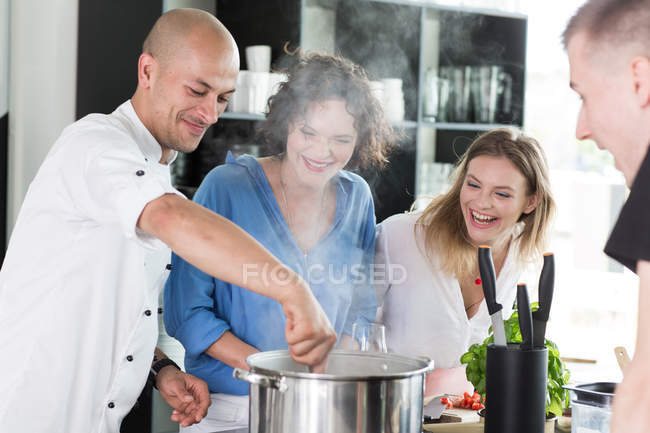 Des gens heureux cuisinant de la soupe — Photo de stock