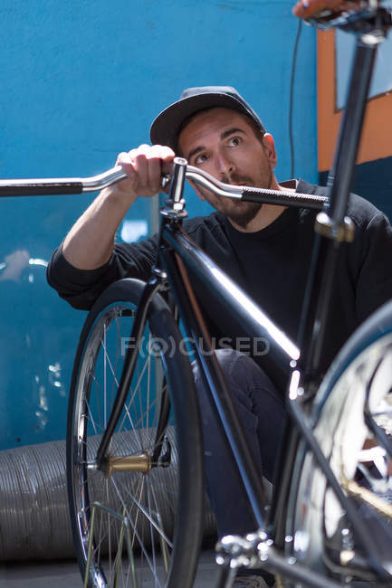 Trabajador profesional mirando bicicleta - foto de stock