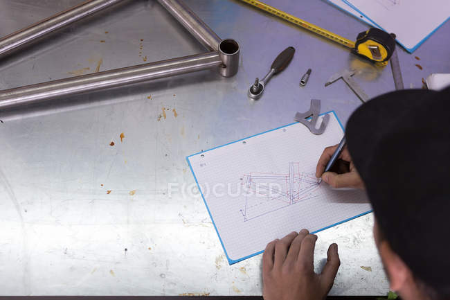 Artigiano disegno bicicletta su tavolo in metallo — Foto stock