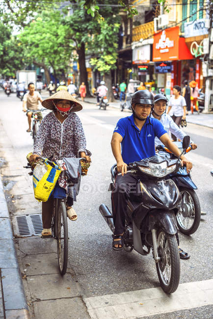 Menschen auf Motorrädern und Fahrrädern in Hanoi — Stockfoto