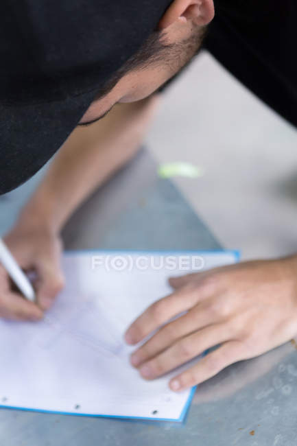 Handwerker zeichnet auf Papier — Stockfoto