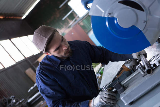 Ouvrier coupe barre métallique — Photo de stock