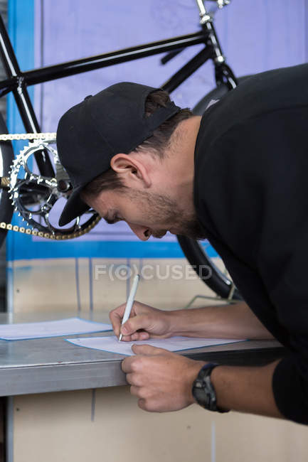Craftsman writing down on paper — Stock Photo