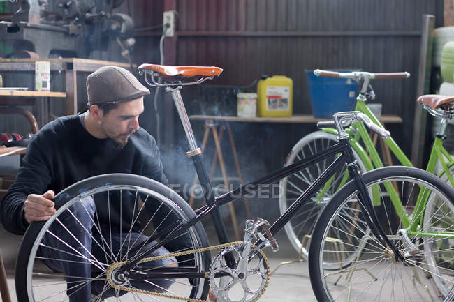 Homem barbudo olhando para a bicicleta — Fotografia de Stock