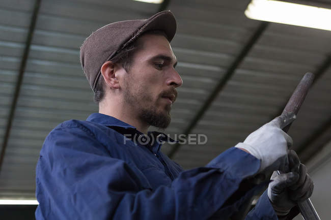 Trabalhador segurando barras de ferro — Fotografia de Stock