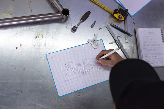 Craftsman doing drawing of bicycle — Stock Photo