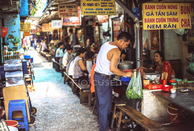 Customers on street stall in Hanoi — Stock Photo