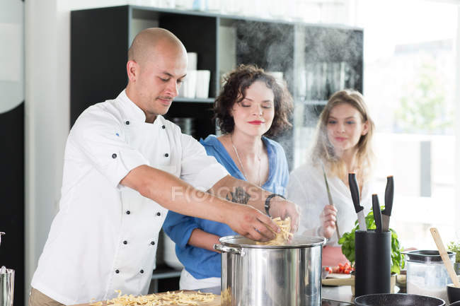 Chef enseignant la cuisine aux femmes — Photo de stock