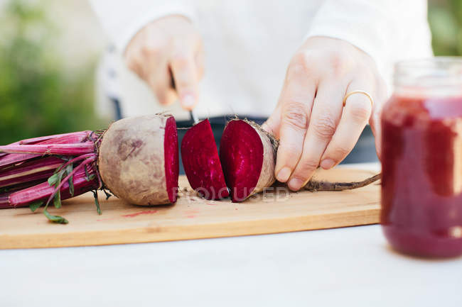 Mãos femininas cortando beterraba fresca — Fotografia de Stock