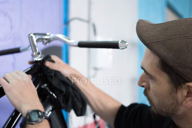 Craftsman cleaning bike with towel — Stock Photo