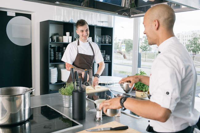 Шеф-кухар посміхається студенту на кухні — стокове фото