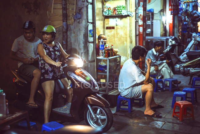Personas y tráfico nocturno en Hanoi - foto de stock