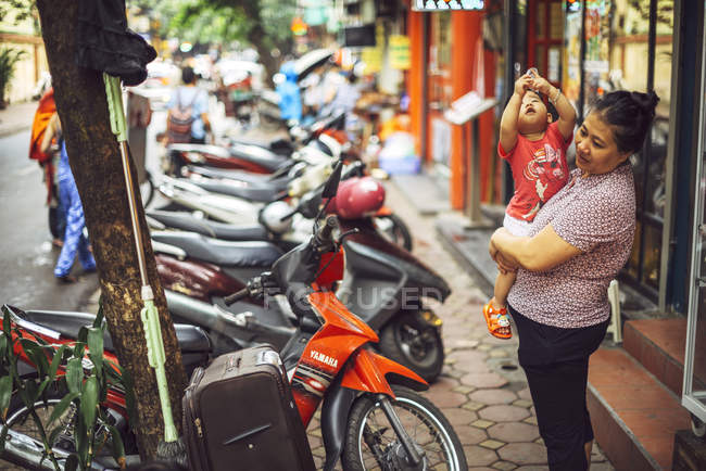 Femme avec bébé dans la rue à Hanoi — Photo de stock