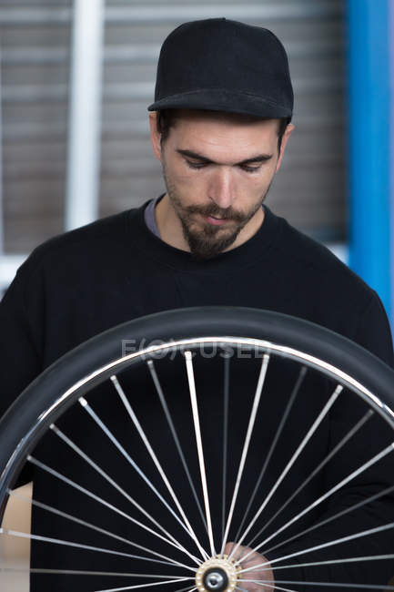 Craftsman looking at bicycle wheel — Stock Photo