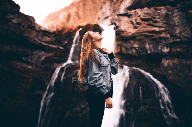 Bella donna vicino pittoresca cascata — Foto stock