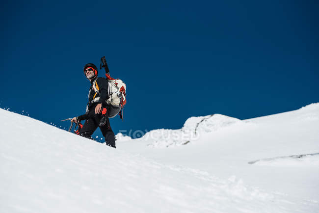 Homem trekking na montanha nevada — Fotografia de Stock