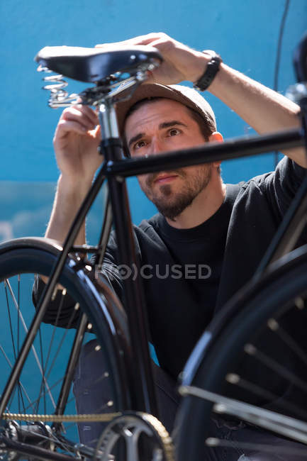 Hombre barbudo mirando bicicleta - foto de stock