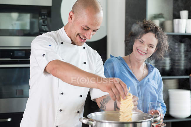 Chef enseñando a la mujer a cocinar sopa - foto de stock