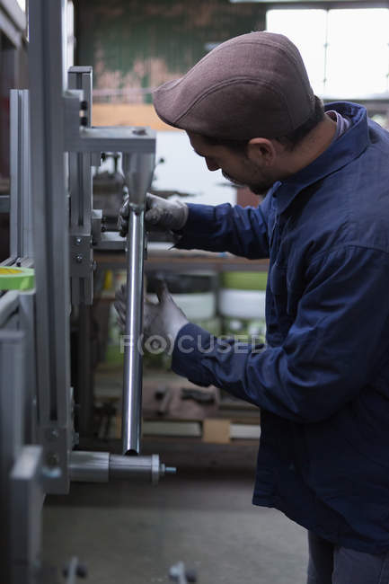 Homme travaillant avec un cadre métallique — Photo de stock