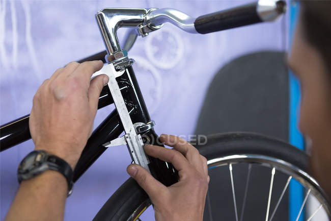 Man taking measurements of bicycle — Stock Photo