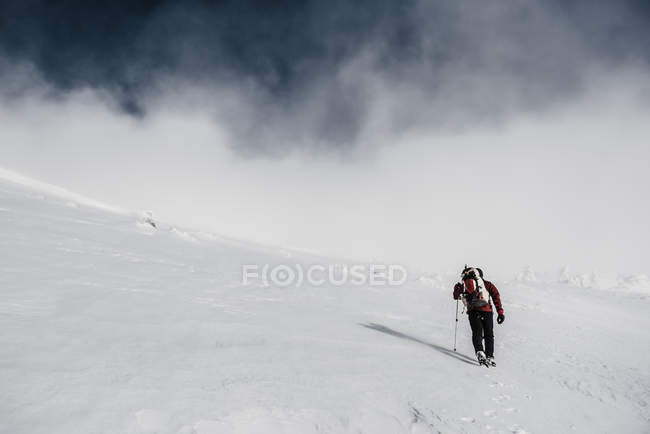 Trekking uomo sulla montagna innevata — Foto stock