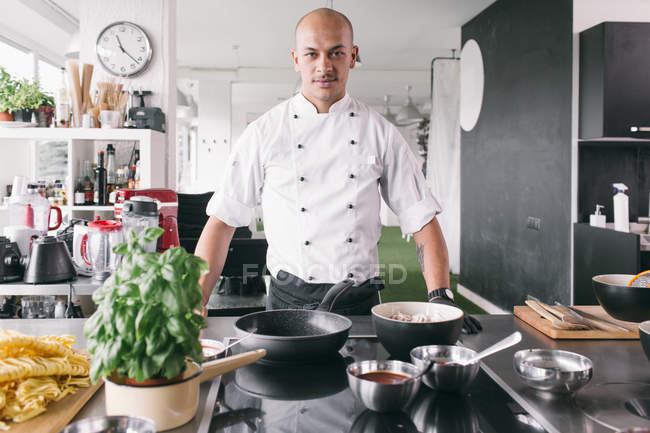 Handsome cook standing in kitchen — Stock Photo