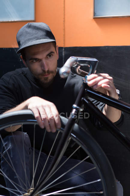 Серьезный человек смотрит на велосипед — стоковое фото