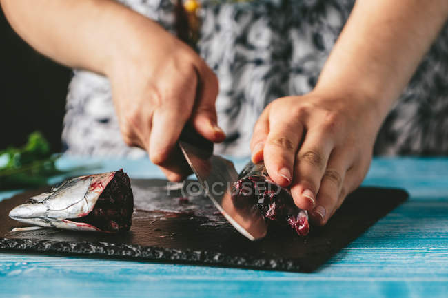 Женщина режет свежую скумбрию — стоковое фото