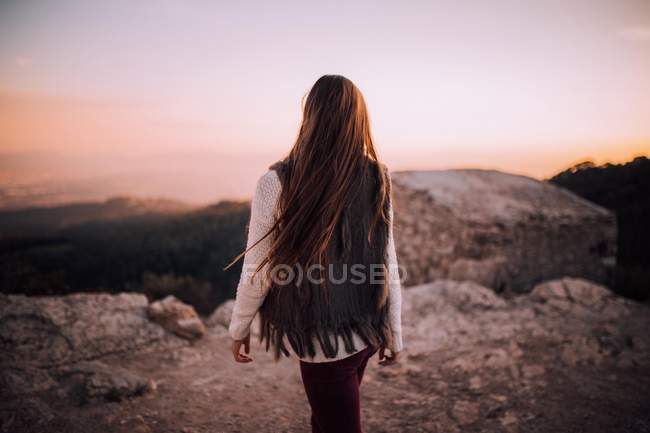 Молодая девушка на каменном краю — стоковое фото