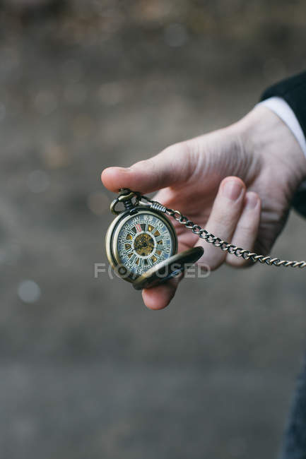 Hand holding vintage pocket watch — Stock Photo