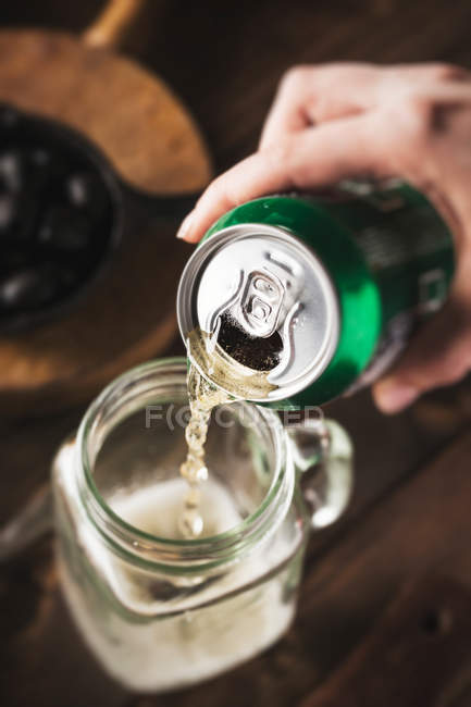 Hand pouring soda — Stock Photo