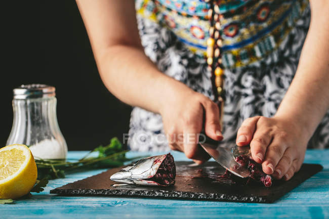 Femme coupant le maquereau frais — Photo de stock