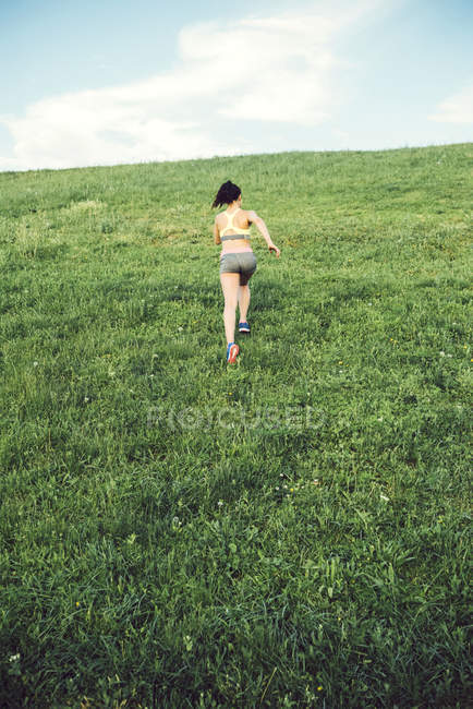 Donna che corre sopra una piccola collina — Foto stock