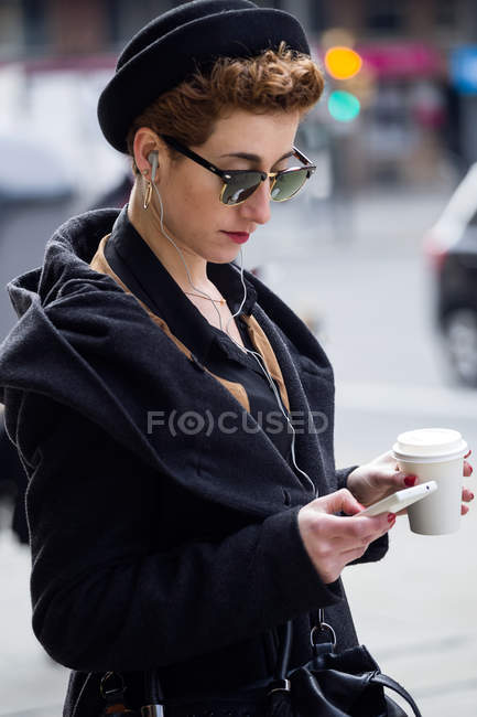 Mujer con teléfono móvil y café . - foto de stock