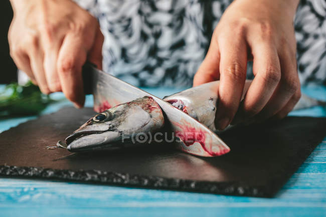 Mujer cortando caballa fresca - foto de stock